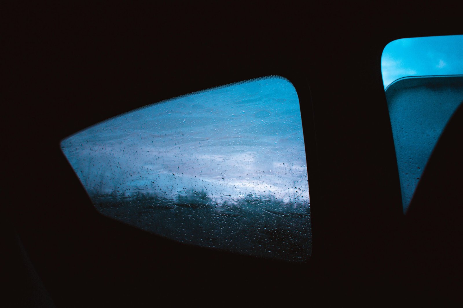 An artistic view through a car window with raindrops, showcasing the mood of a rainy day.